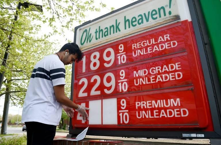 Un employé de station service de Arlington en Virginie change les prix le 21 avril 2020 au moment où les cours du pétrole s'effondrent  ( AFP / Olivier DOULIERY )